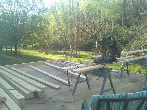Miter saw and framing lumber on a deck under construction in Trenton